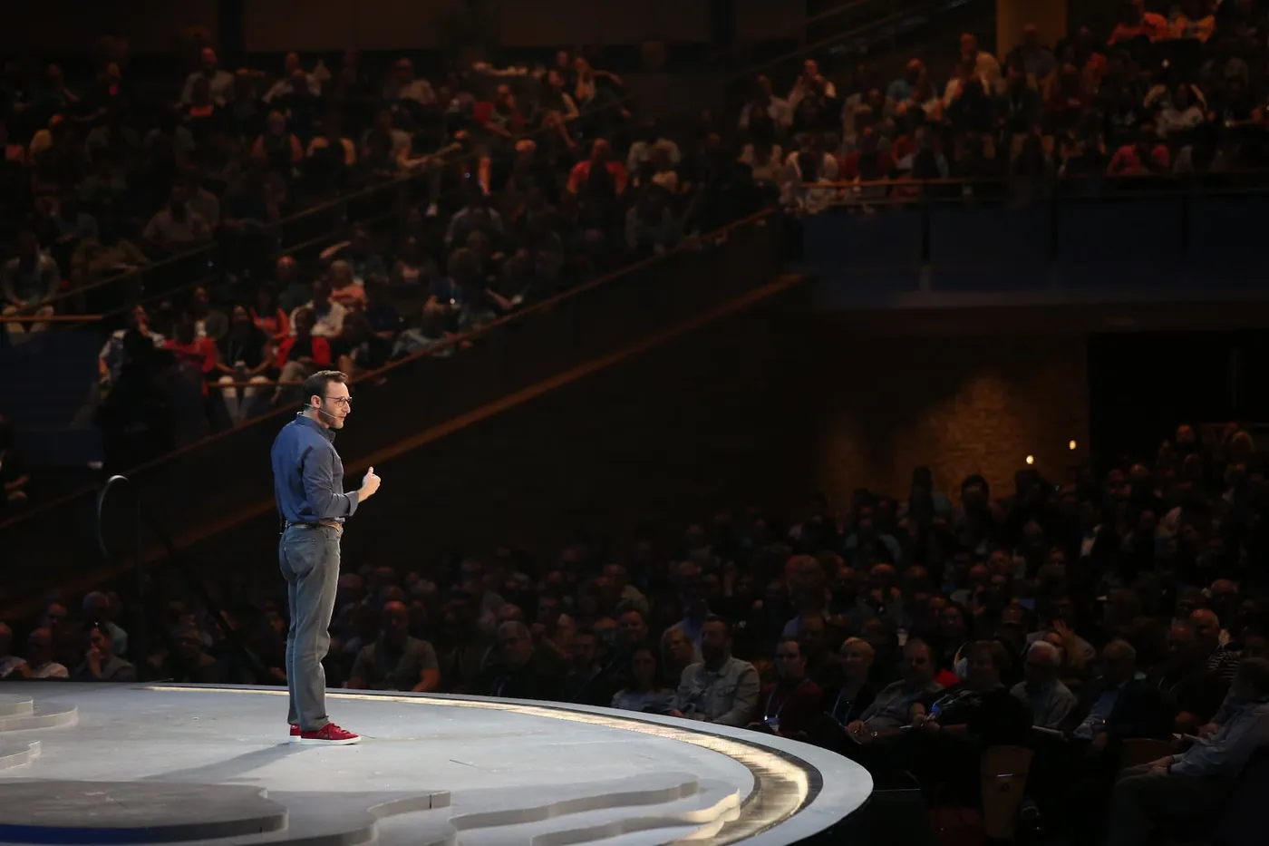 Simon Sinek speaking to a packed auditorium from the stage
