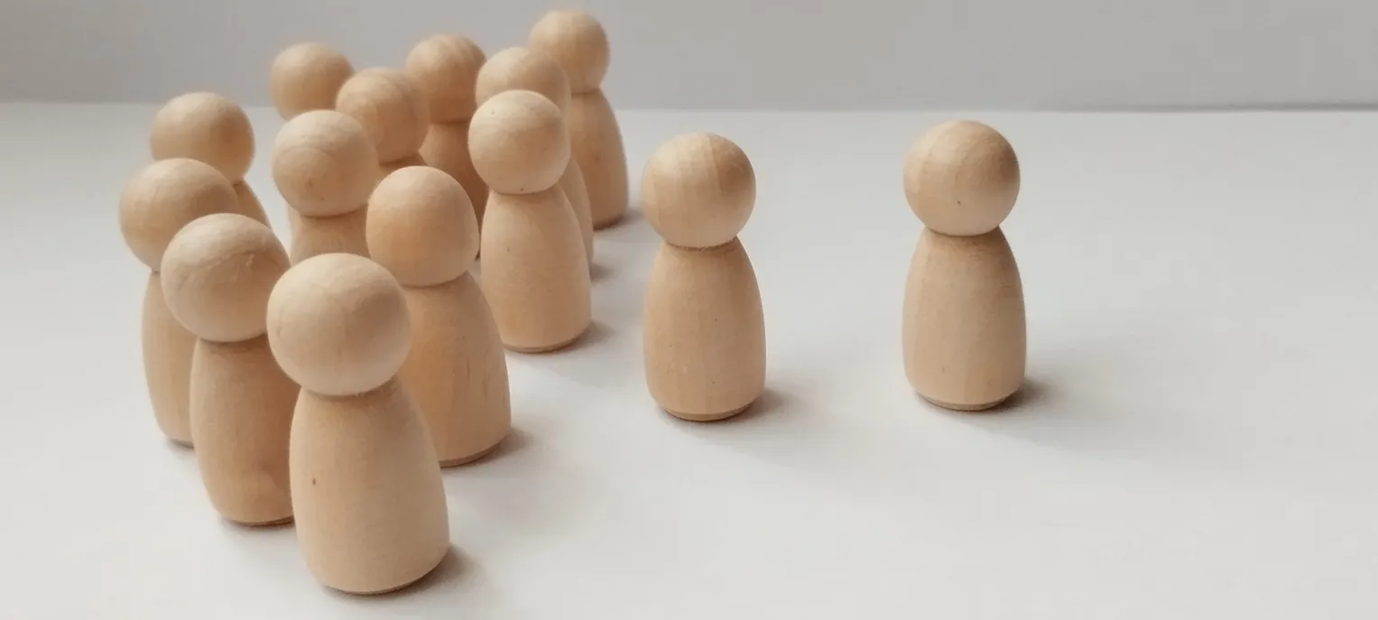 Group dynamics social interaction of wooden figurines minimalist studio photography neutral background close-up conceptual exploration