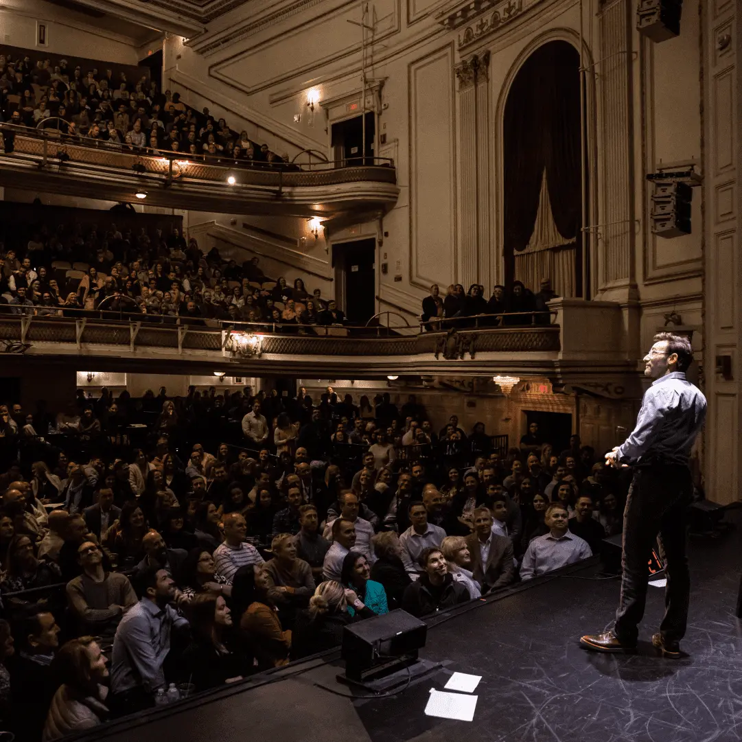 Simon Sinek speaking to a crowded theater