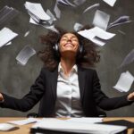 business woman wearing headphones and joyous as paper flows around her